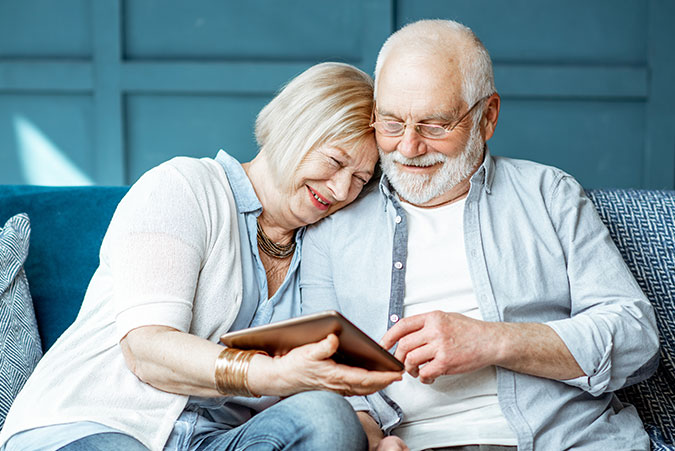 Senior Couple Smiling using a tablet