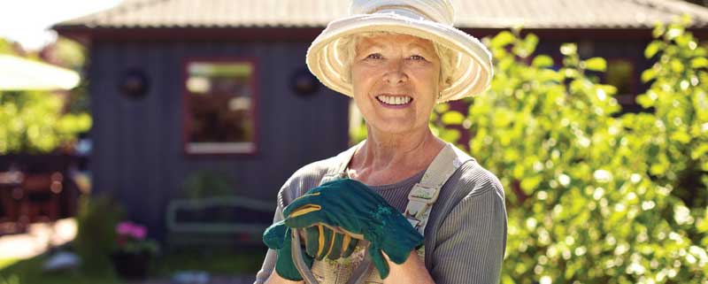 Woman smiling while she is working outside in her yard