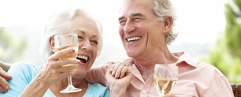 Husband and wife laughing and holding champagne