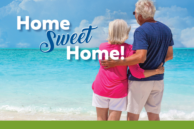 An older couple stands on a beach, facing the ocean with arms around each other. The words "Home Sweet Home!" are written above them.
